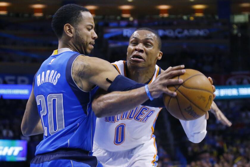 Thunder guard Russell Westbrook is fouled by Mavericks guard Devin Harris on a drive to the basket in the third quarter Thursday night.