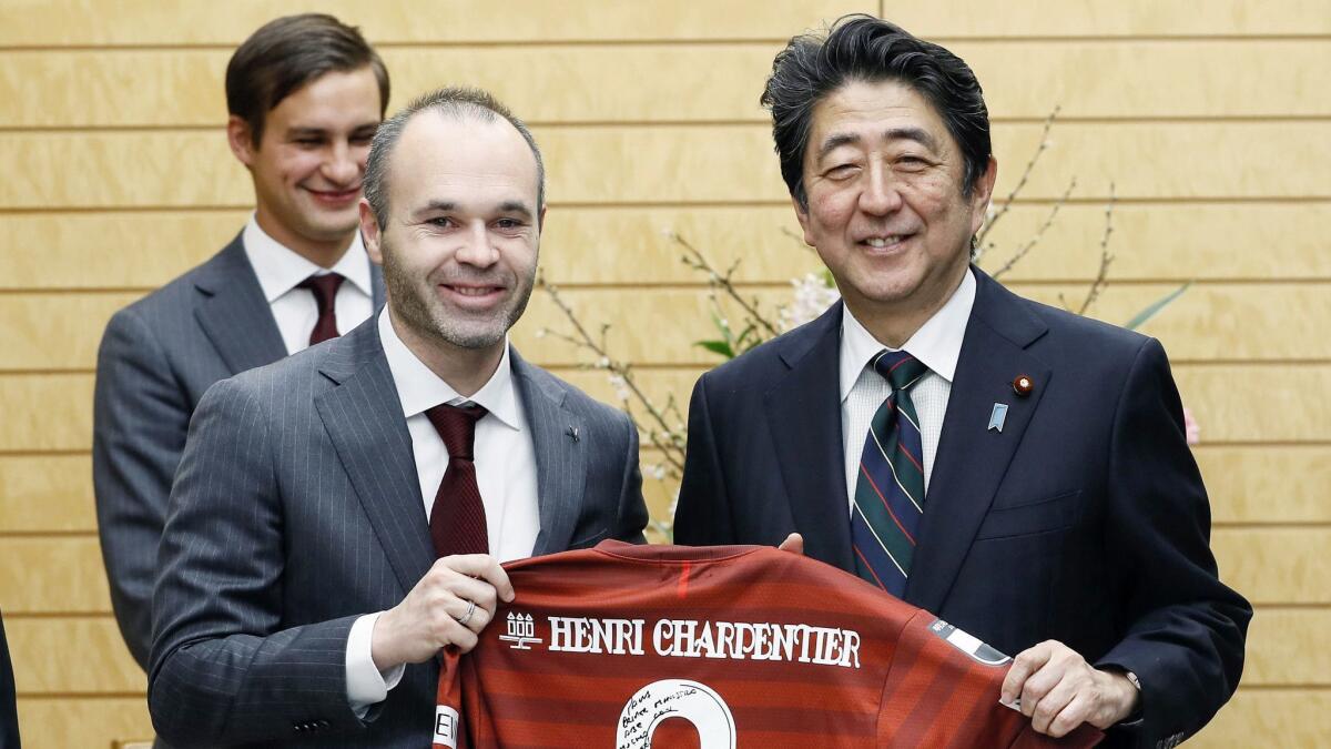 Vissel Kobe's Andres Iniesta, left, presents his team's jersey to Japan's Prime Minister Shinzo Abe at Abe's official residence in Tokyo on Jan. 18, 2019.