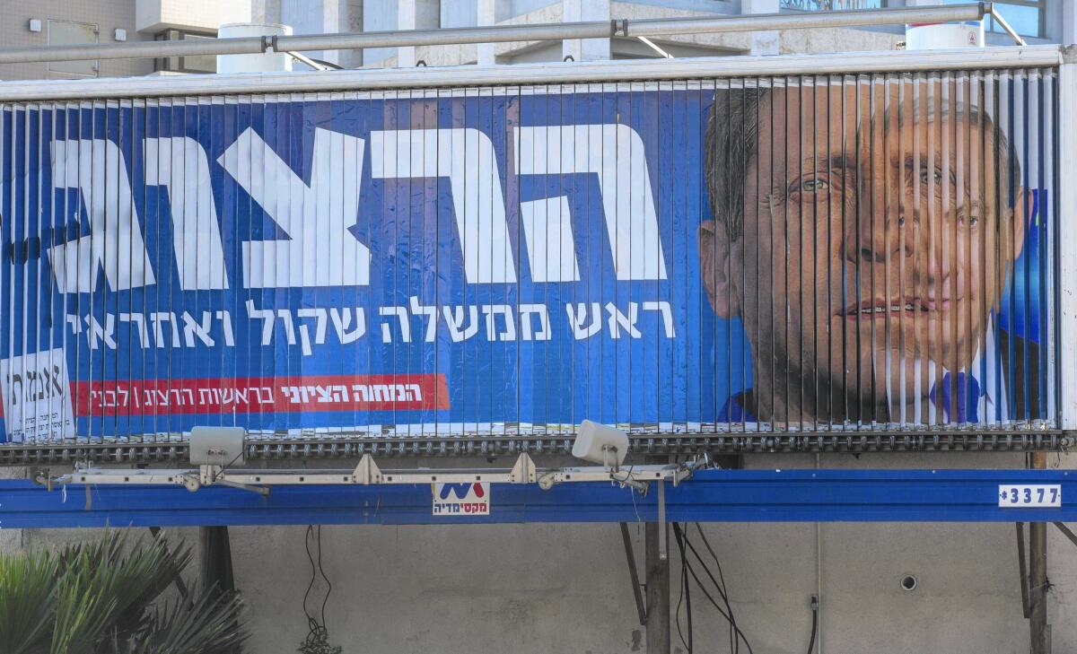 A billboard in Tel Aviv rotates between Isaac Herzog, head of the Zionist Union, left, and Israeli Prime Minister Benjamin Netanyahu.