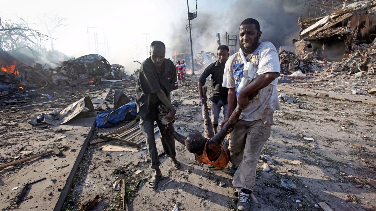 Somalis remove the body of a man killed by an explosion in Mogadishu.