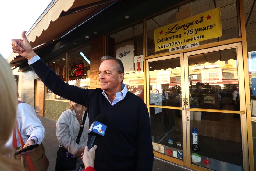LOS ANGELES, CA - NOVEMBER 9, 2022 - - Mayoral candidate Rick Caruso gives a thumbs up as a van of supporters shouted their approval on passing while making a post election stop at Langer's Deli in MacArthur Park in Los Angeles on November 9, 2022. (Genaro Molina / Los Angeles Times)
