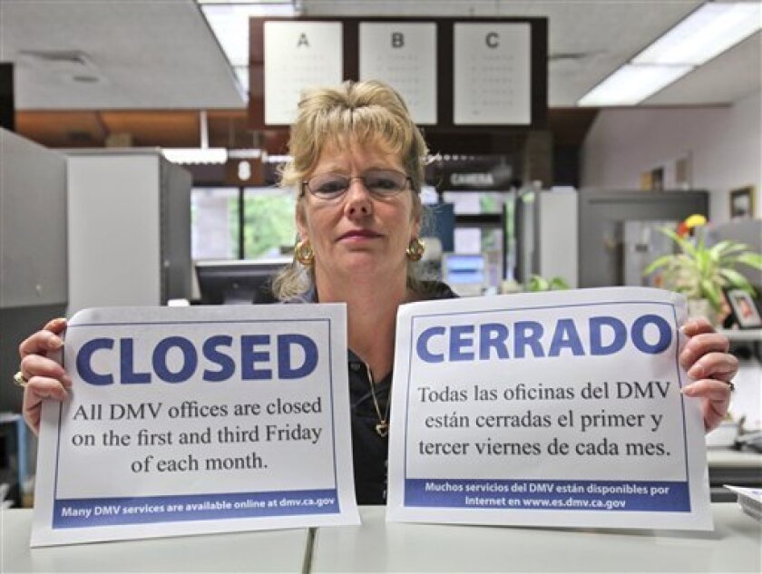 Candy Jackson, manager of the Department of Motor Vehicles office in Placerville, Calif., displays the warning signs that the office will be closed Friday, on Thursday, Feb. 5, 2009. State agencies were preparing Thursday to implement the first employee furloughs in California history, as part of Gov. Arnold Schwarzenegger's attempt to save money, in the face of a massive budget crisis. An estimated 90 percent of the state's 238,000 employees are supposed to be off Friday.(AP Photo/Rich Pedroncelli)
