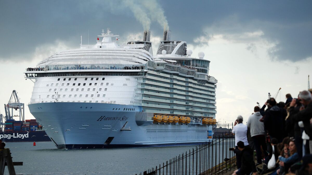 People watch from the shore as the Harmony of the Seas cruise ship sets sail from Southampton, southern England.
