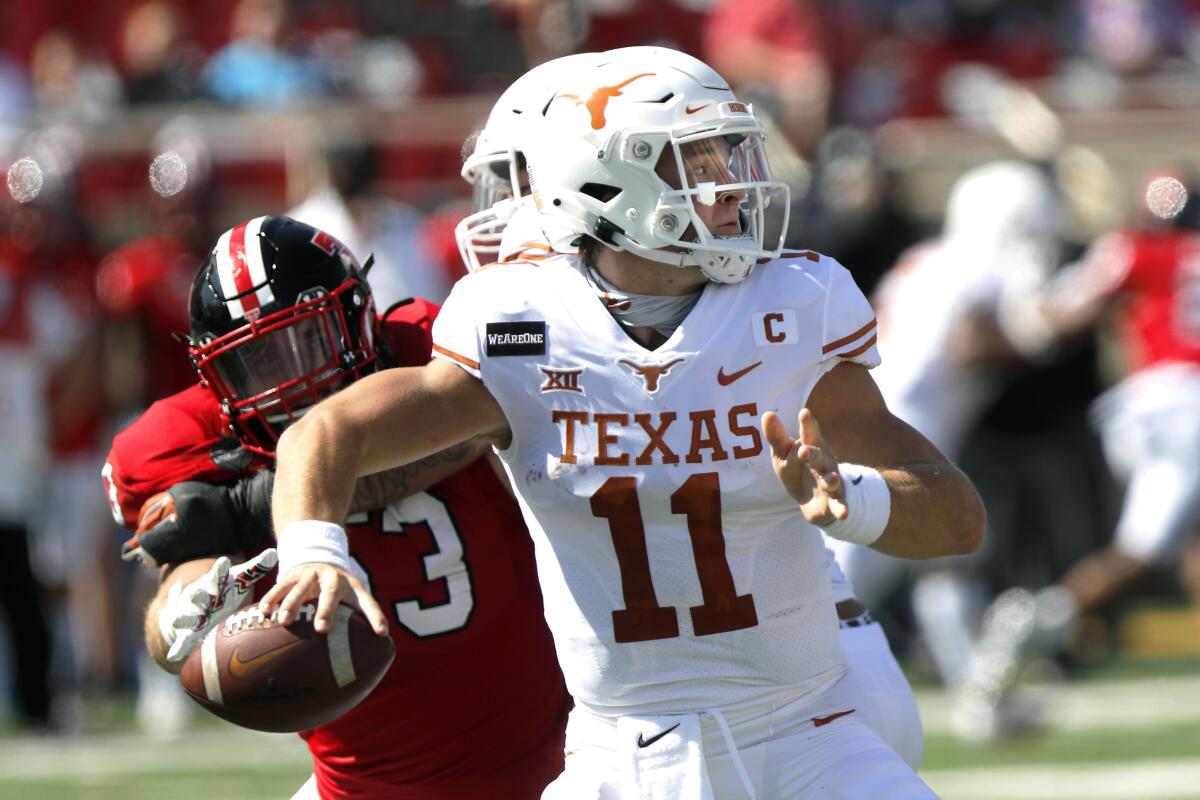 Texas quarterback Sam Ehlinger passes under pressure from Texas Tech defensive lineman Eli Howard in September.