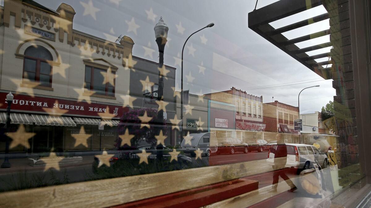 Buildings along Park Avenue are reflected in a storefront window in the historic downtown section of Idaho Falls.