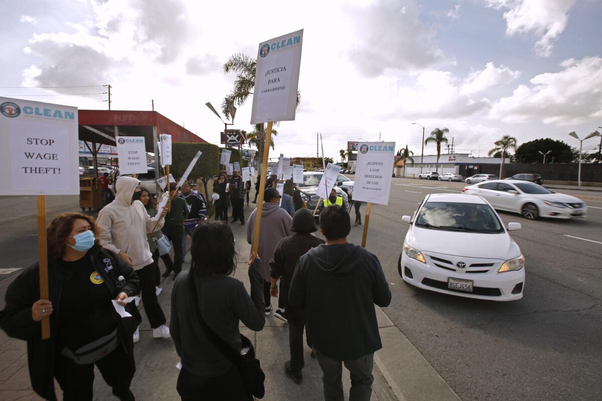 Protesters block a car from entering a carwash. 