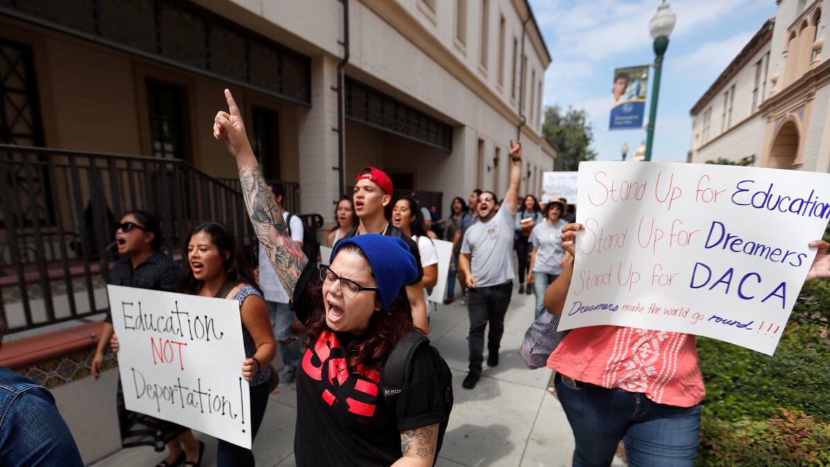 Liz Sanchez, center, a graduate student at Cal State Fullerton, joins students marching around Fullerton College in solidarity with DACA recipients.