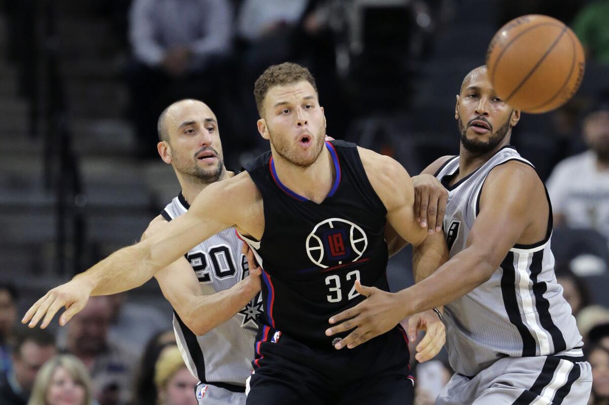 Clippers forward Blake Griffin passes the ball as he is pressured by San Antonio Spurs guard Manu Ginobili, left, and center Boris Diaw on Dec. 18.