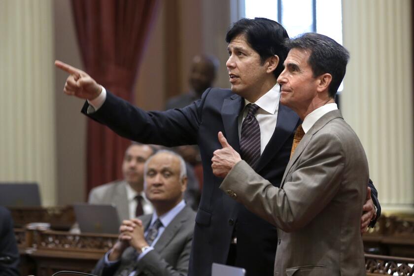 State Sen. Mark Leno, right, and Senate President Pro Tem Kevin de León watch as votes on the minimum wage bill are posted in the Capitol on March 31. The bill, which would raise the wage to $15 an hour by 2022, was approved by both houses of the Legislature.