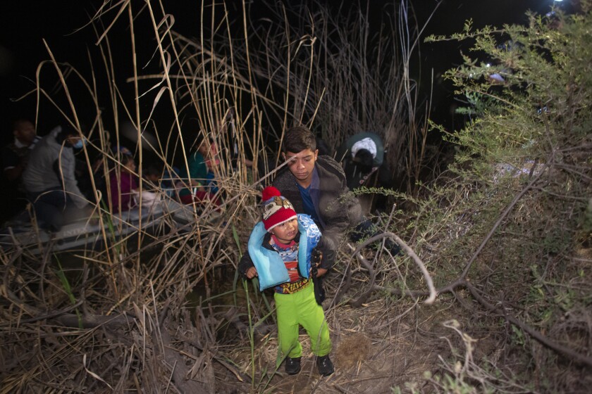 A child weeps as he is unloaded from an inflatable raft after being smuggled into the United States across the Rio Grande in Roma, Texas, on March 28, 2021. (AP Photo/Dario Lopez-Mills)