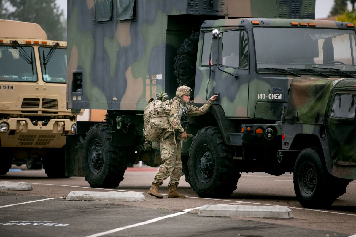 National Guard troops gathered equipment from vehicles outside the La Mesa Civic Center June 4.