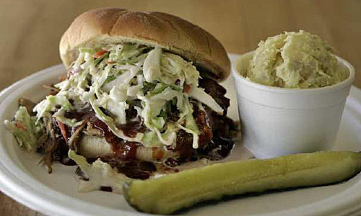 A pulled pork sandwich topped with coleslaw and barbecue sauce at Scottie's Smokehouse in Orange.