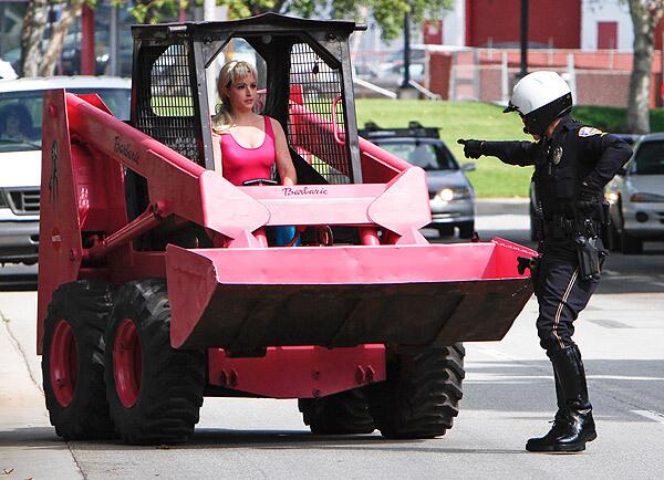 Elise Nabors, wearing a Barbie outfit and driving a pink skip loader, is stopped by a police officer near Mattel's headquarters in El Segundo during a protest that accused the toy maker of using packaging material from Indonesian rain forests. See full story