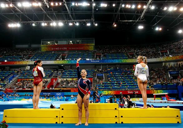 U.S. gymnast Shawn Johnson approaches the medals podium to accept her gold medal. Bronze medalist Cheng Fei of China is left and Nastia Liukin of the U.S. is the silver medalist.