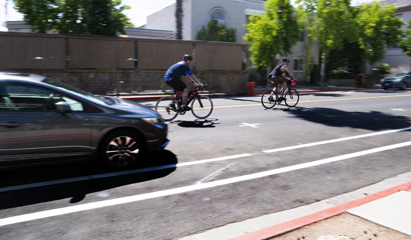 Bicyclists ride in new bike lanes recently painted by the city along Park Boulevard in University Heights
