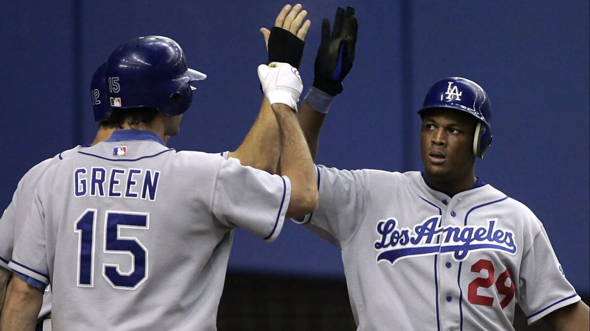 Adrian Beltre, right, is congratulated by Dodgers teammates Shawn Green and Steve Finley after hitting a two-run home run against the Montreal Expos on Aug. 23, 2004.