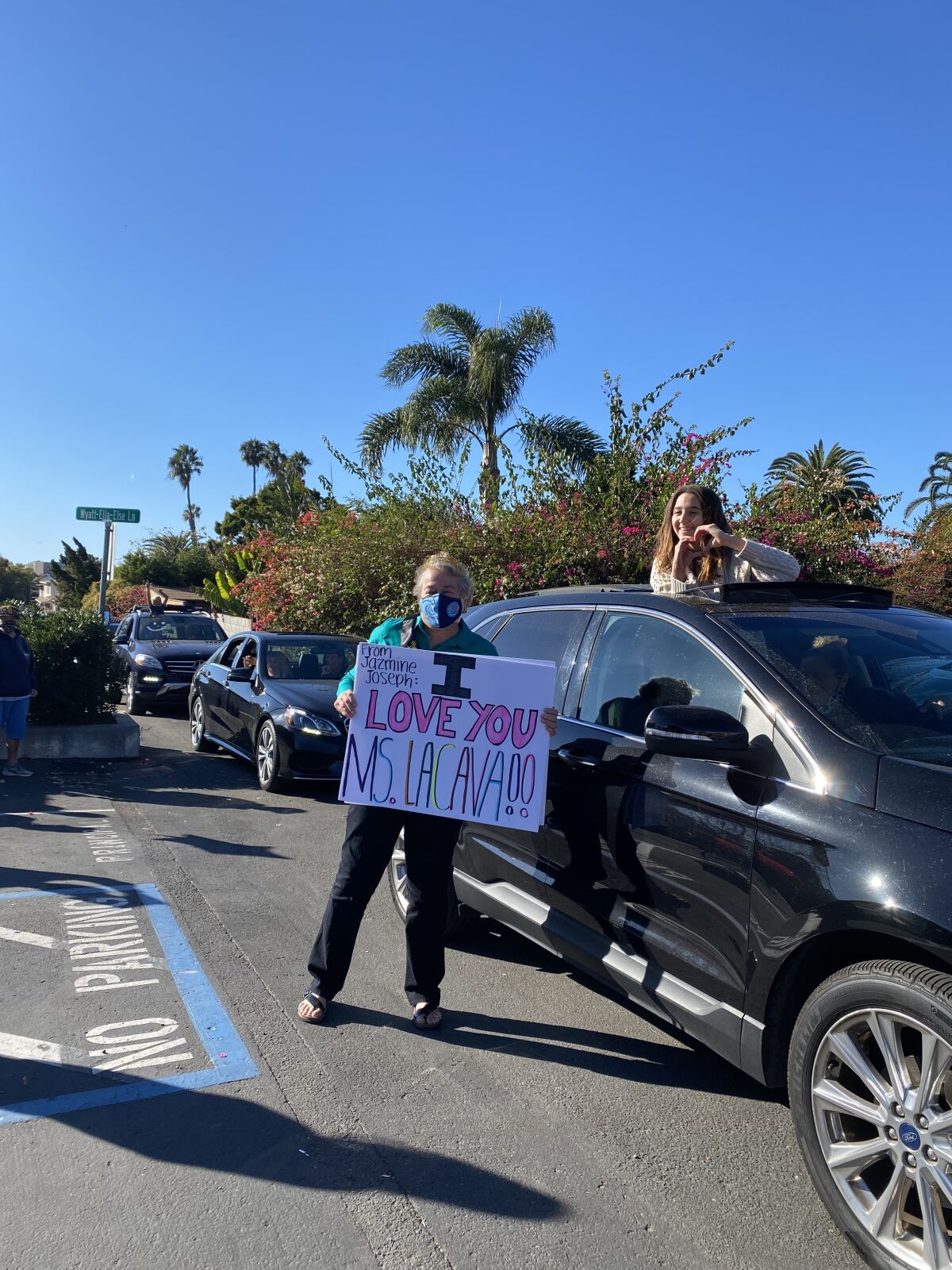 Lorene LaCava, left, holds a sign made for her during a surprise parade