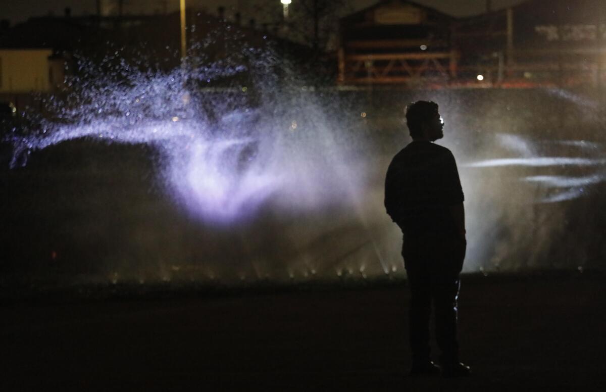 An audience member is framed by a mist projection which is part of the performance of, "Sweet Land," at Los Angeles State Historic Park on February 21, 2020.