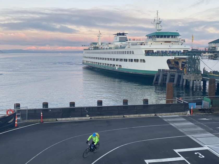 A cyclist rides into downtown Seattle on Monday morning after arriving on a ferry. Fewer passengers are riding ferries as authorities try to slow the spread of coronavirus by encouraging people to work from home.