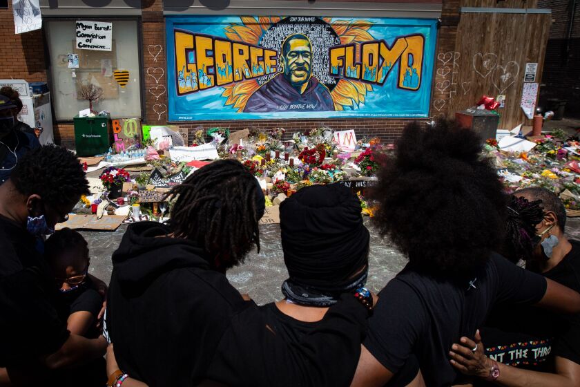 MINNEAPOLIS,MINNESOTA - JUNE 01: The Holloway family stands where George Floyd was killed. (Jason Armond / Los Angeles Times)