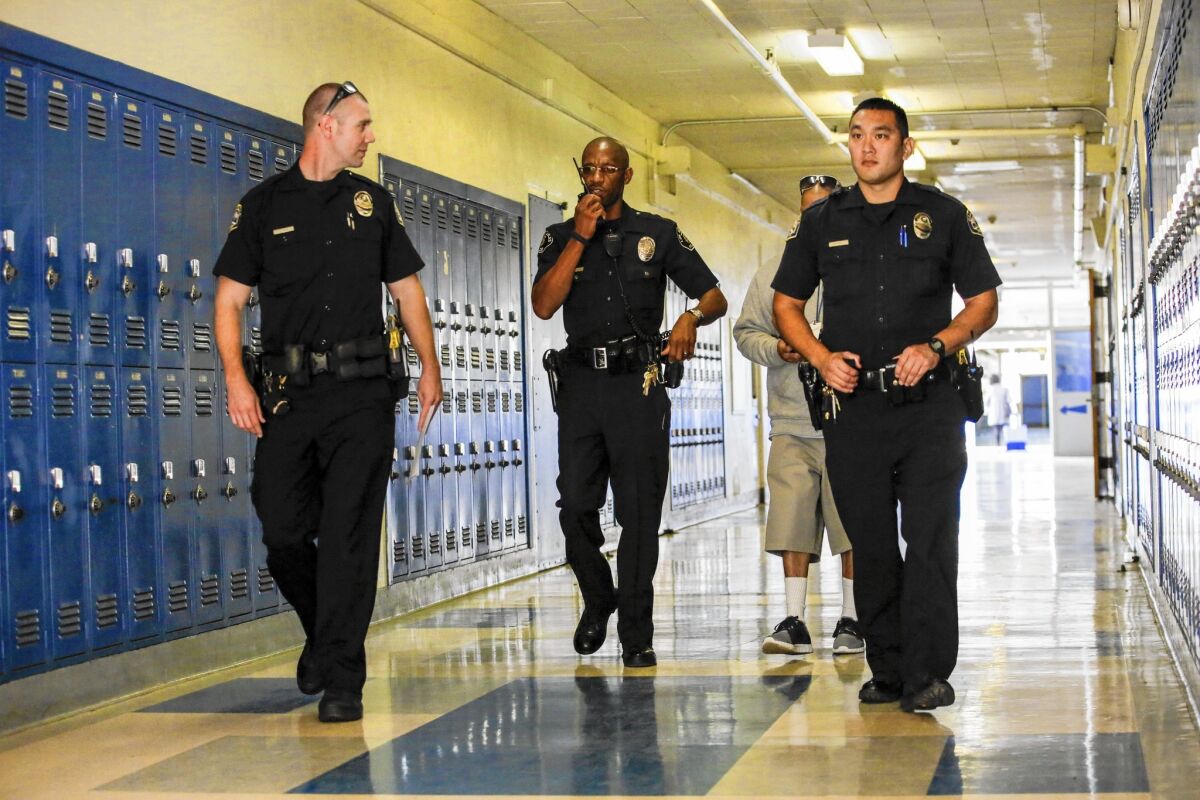 Officer Henry Anderson, middle, patrols Peary Middle School with two Gardena police officers. Starting last year, the district stopped citing for most fights, petty thefts and other minor offenses in favor of redirection into counseling programs