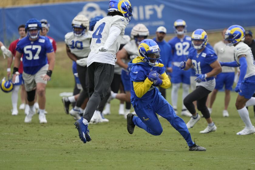 Rams receiver Tutu Atwell runs past safety Jordan Fuller (4) after a catch during organized team activities.