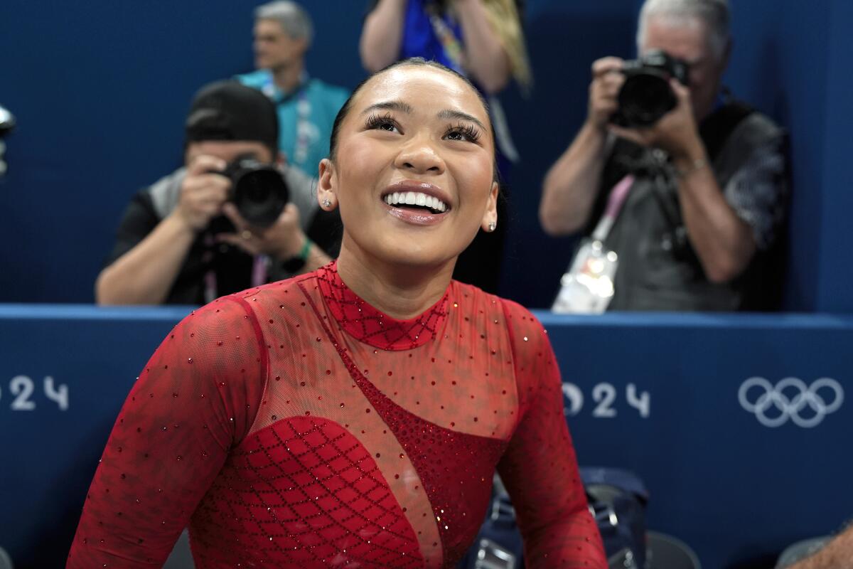 Suni Lee, of the United States, smiles after winning the bronze medal.