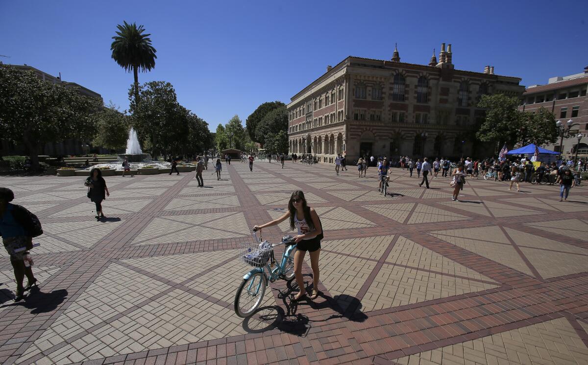 Students walking and on bikes roam the USC campus in 2014