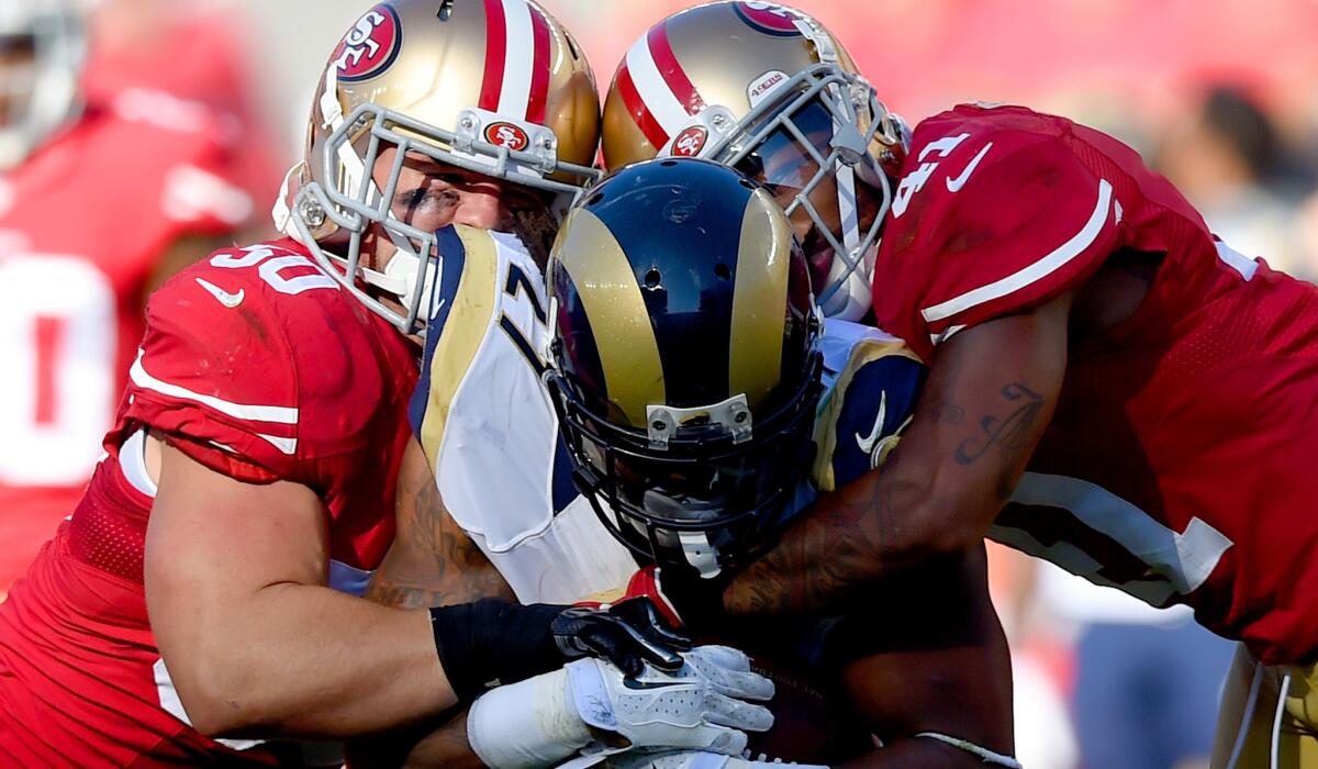 49ers linebacker Chris Borland, left, and defensive back Antoine Bethea collide with Rams running back Tre Mason during a game last season at Levis' Stadium.