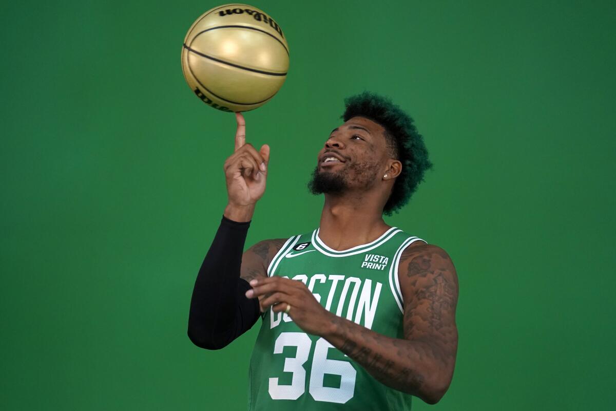 El base de los Celtics de Boston Marcus Smart gira un balón con la punta del dedo 
