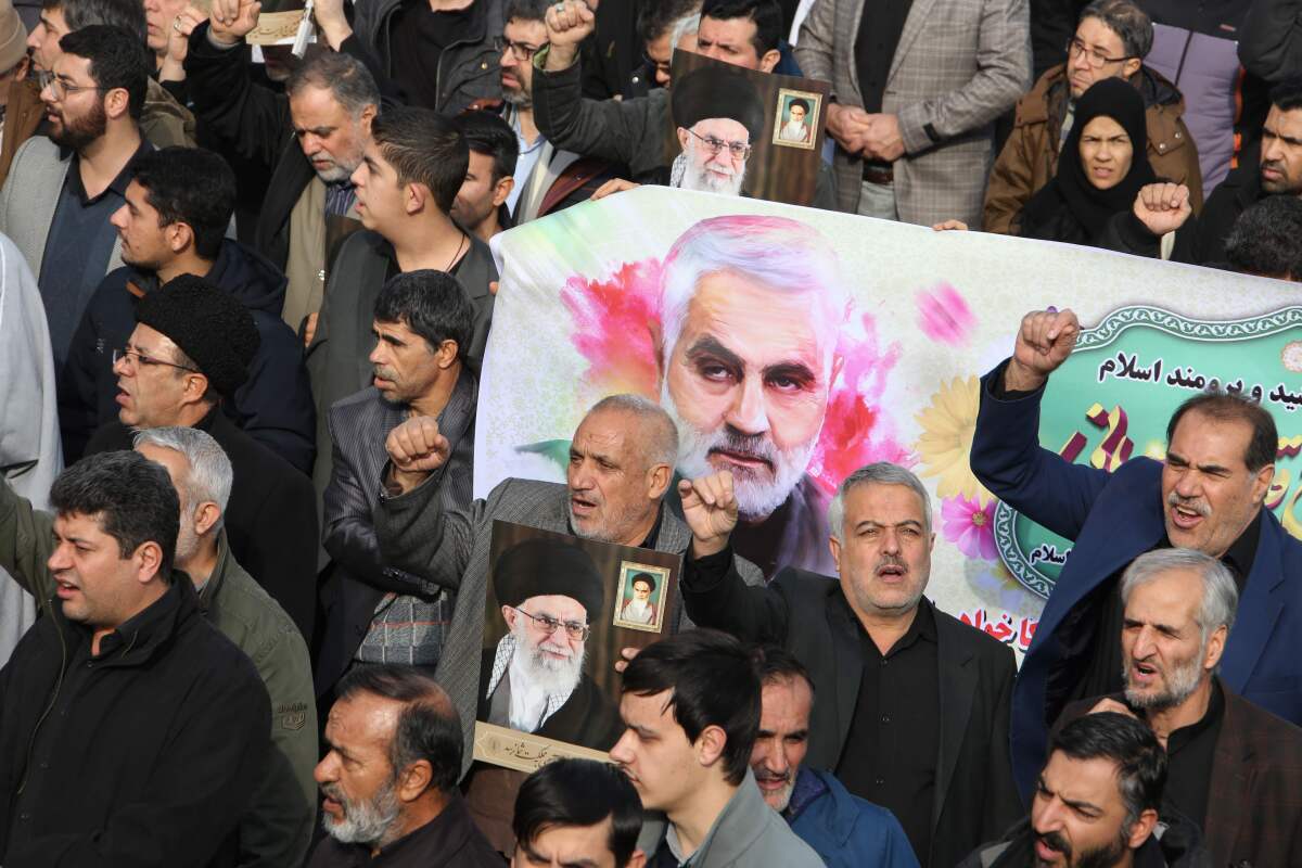 Iranians march with a banner bearing an illustration of Quds Force leader Qassem Suleimani during a demonstration in Tehran on Friday.