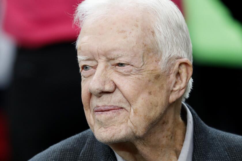 FILE - Former President Jimmy Carter sits on the Atlanta Falcons bench before the first half of an NFL football game between the Atlanta Falcons and the San Diego Chargers, Oct. 23, 2016, in Atlanta. Former President Carter, on Saturday Sept. 23 2023 made a surprise appearance at the Plains Peanut Festival in their Georgia hometown, the Carter Center wrote in a social media post on X, formerly known as Twitter. (AP Photo/John Bazemore, File)