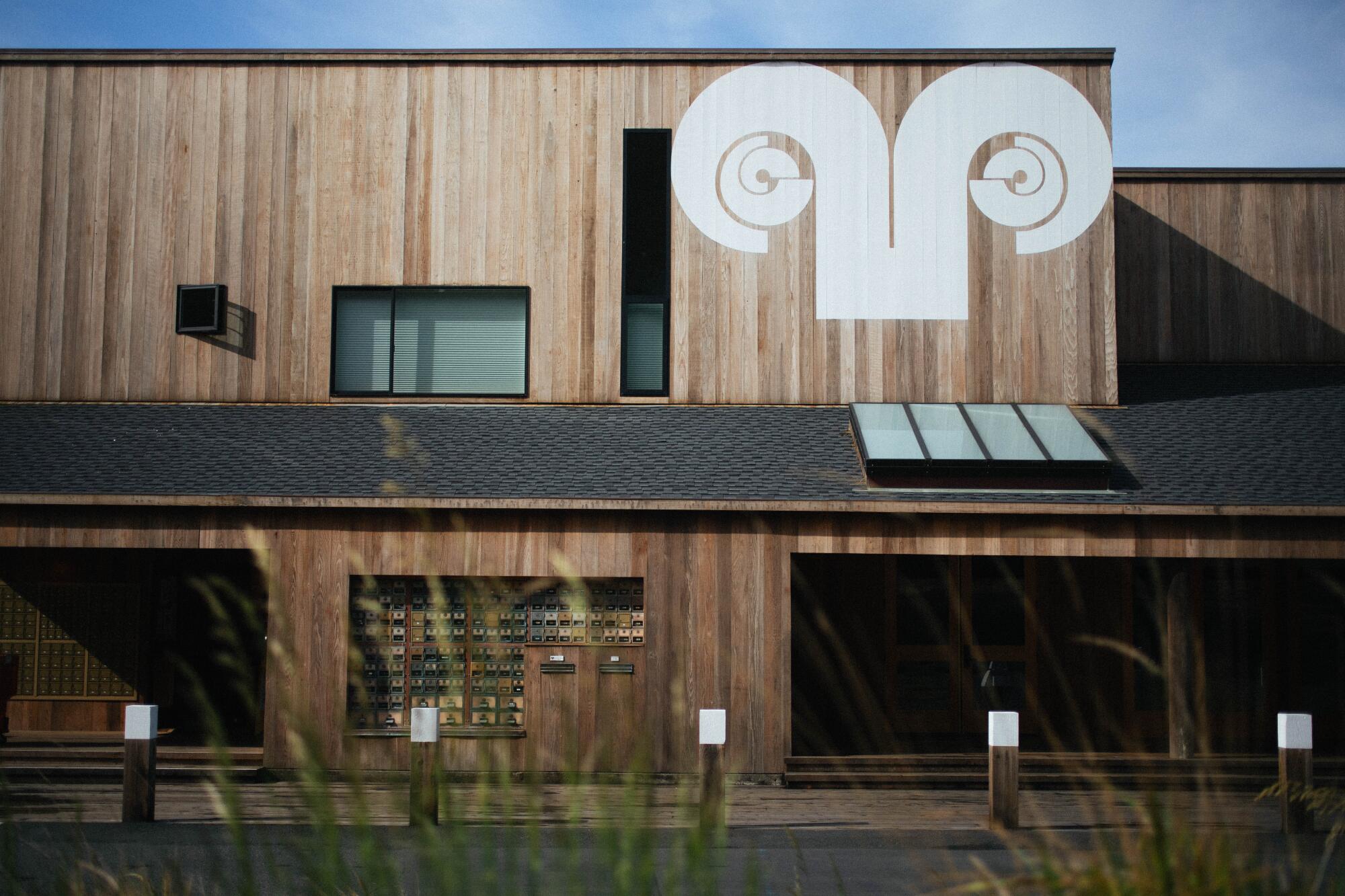 A white design of ram's horns painted on a wooden building