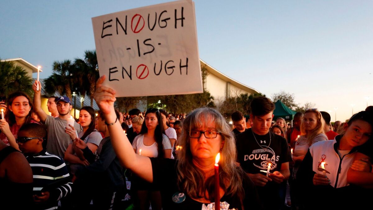 Mourners stand during a candlelight vigil for the victims of the Marjory Stoneman Douglas High School shooting in Parkland, Fla. on Feb. 15.
