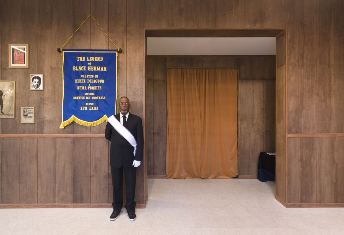 An usher stands by a room in an art gallery.