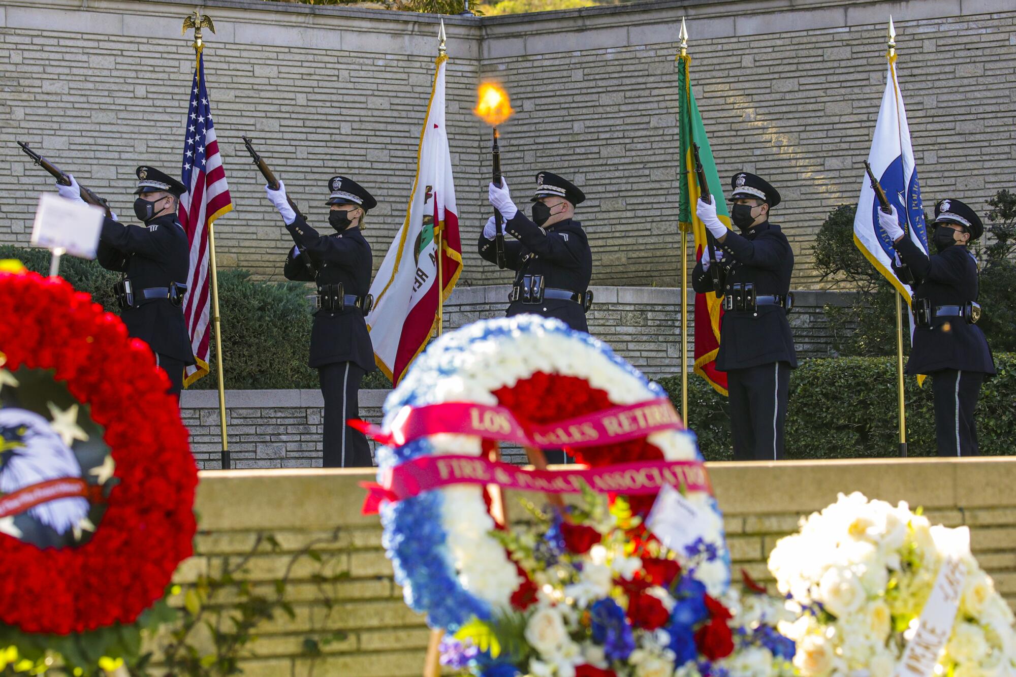 An honor guard conducts a gun salute at LAPD Officer Fernando Arroyos' funeral.