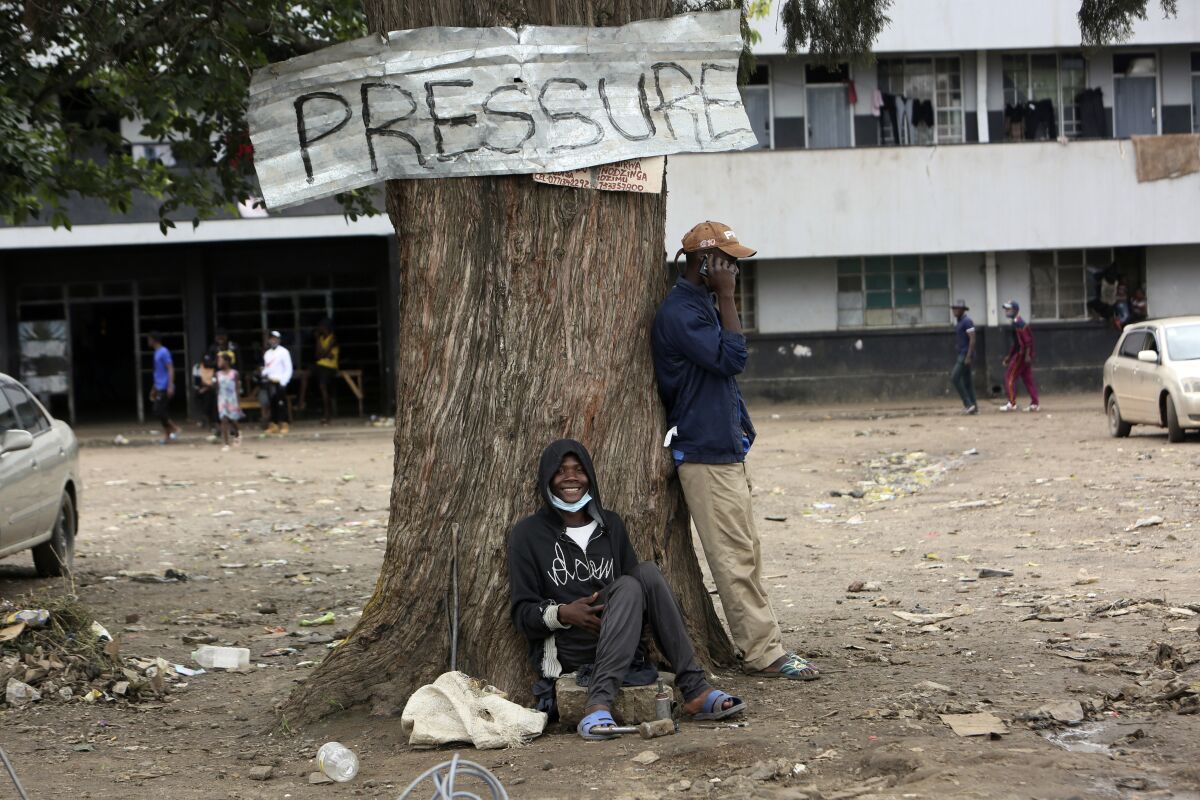 A man smiles while sitting under a tree in Harare, Zimbabwe, Thursday, Sept, 16, 2021. Zimbabwe has told all government employees to get vaccinated against COVID-19 or they will not be allowed to come to work. It wasn’t made clear what would happen to those who refused to be vaccinated. (AP Photo/Tsvnagirayi Mukwazhi)