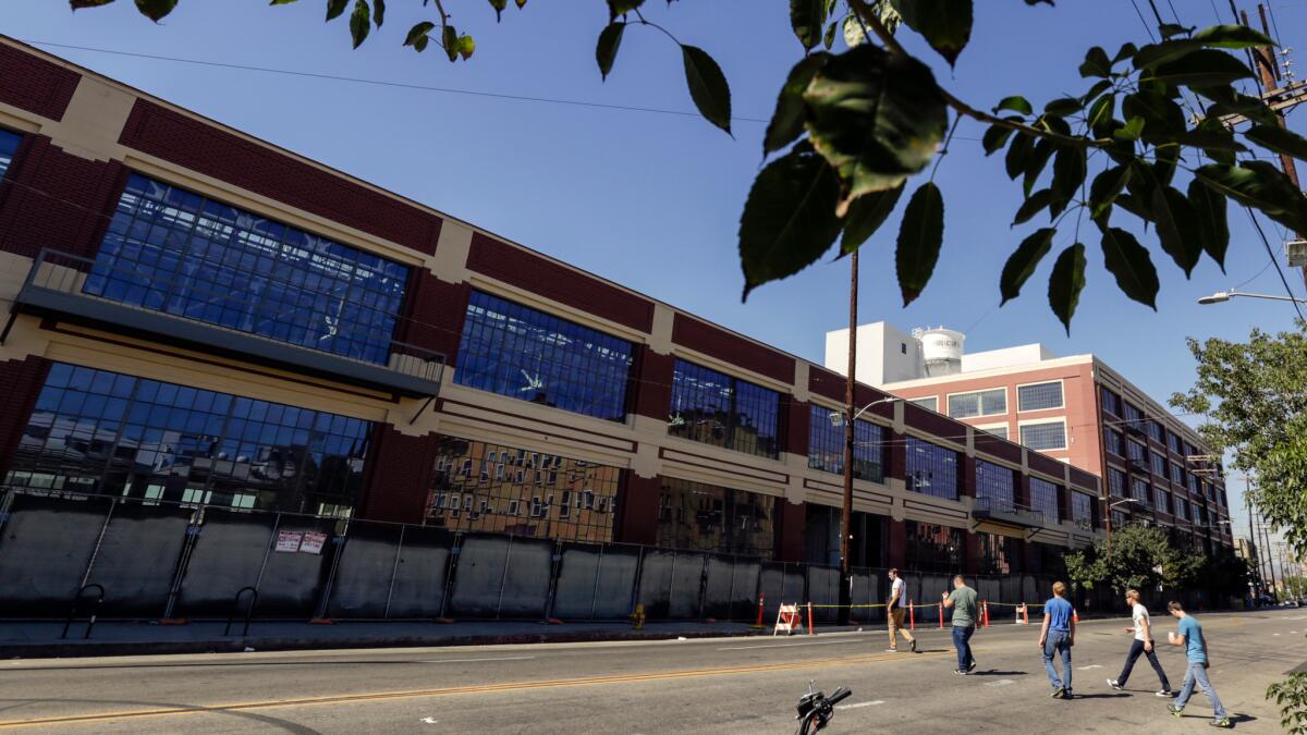 Warner Music Group plans to move hundreds of employees from Burbank and the Westside into a renovated former auto plant in the downtown Arts District.