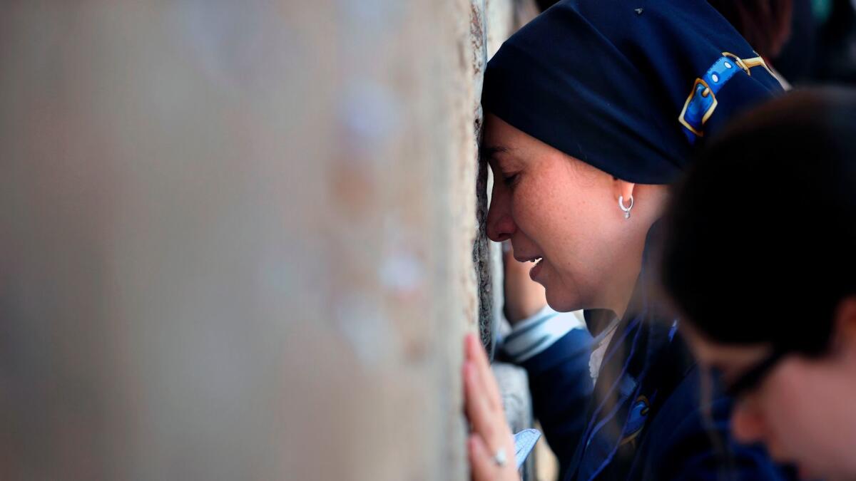 Jewish women pray at the men's section of the Western Wall in Jerusalem's Old City. Israel is shelving a deal to allow men and women to pray together at the Western Wall.