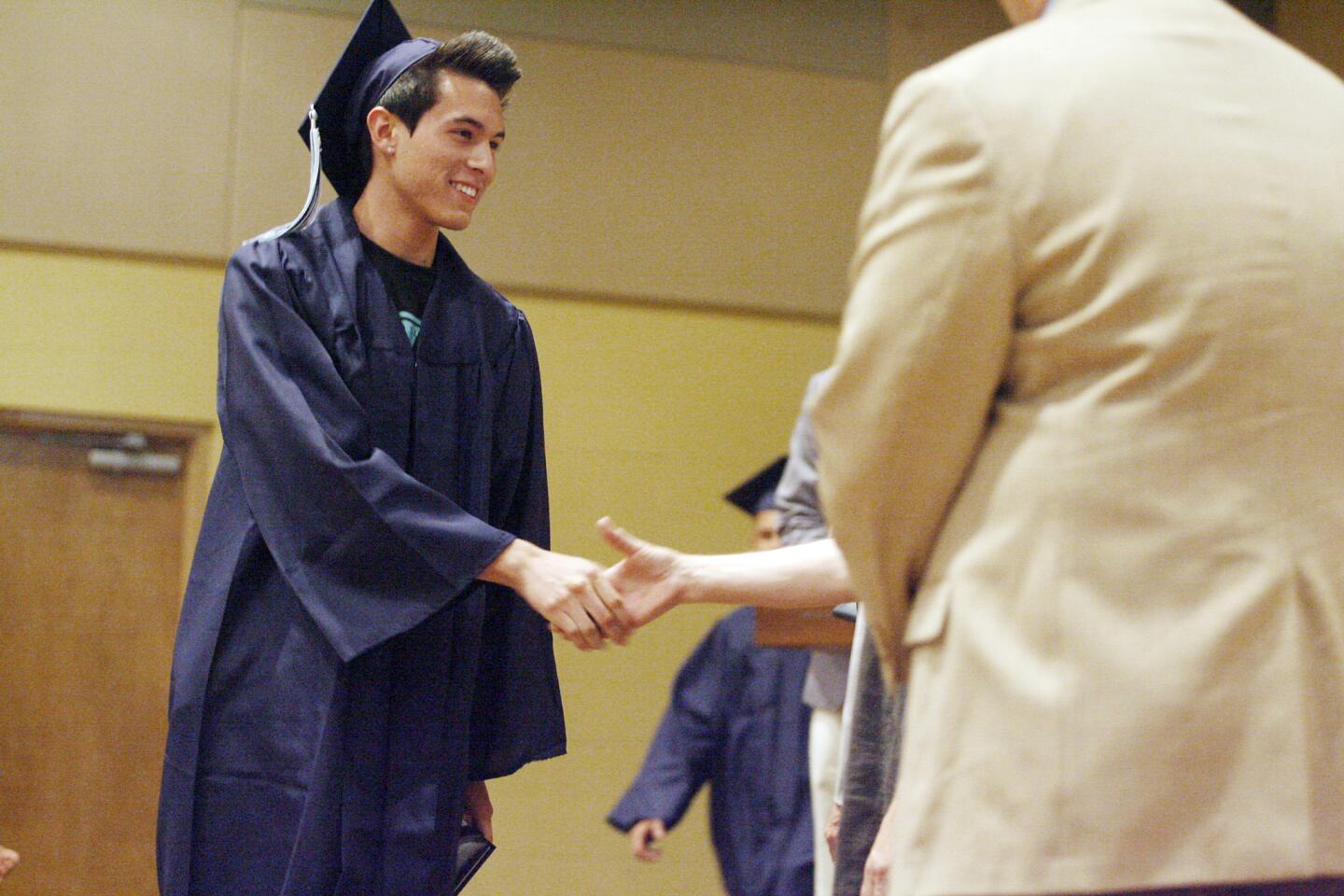 Christian Dominguez receives his diploma during his graduation ceremony at United Methodist Church in Glendale on Thursday, July 19, 2012.