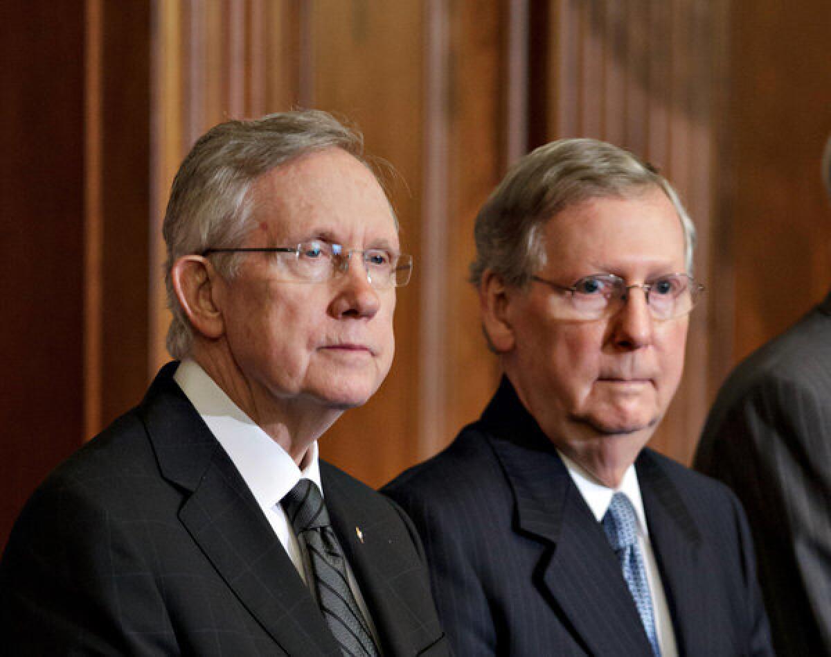 In this July 2012 photo, Senate Majority Leader Harry Reid (D-Nev.) and Senate Minority Leader Mitch McConnell (R-Ky.) participate in an award ceremony at the U.S. Capitol in Washington. The two Senate leaders reached a deal Tuesday to avert a move by Reid to end Senate filibusters on presidential nominees for executive branch posts.