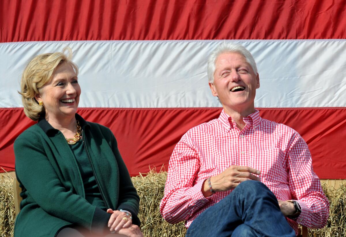 Former President Bill Clinton and his wife former Secretary of State Hillary Rodham Clinton laugh during a speech by then-Sen. Tom Harkin in Iowa in 2014.