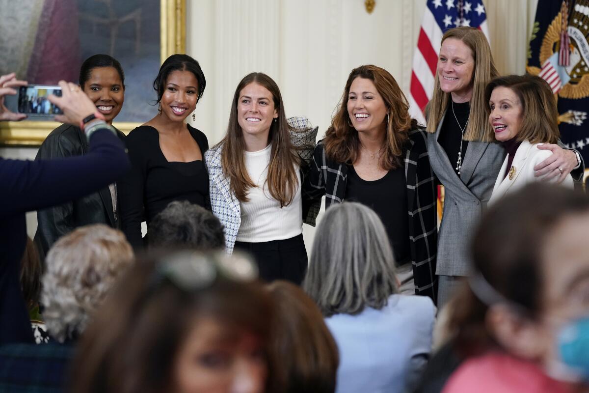 Cindy Parlow Cone, second from right, poses with House Speaker Nancy Pelosi, right, and U.S. women's soccer players.