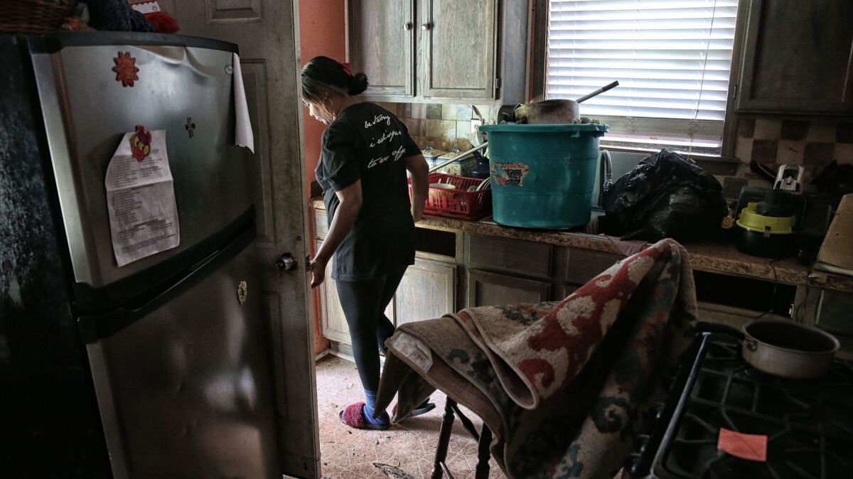 Yvonne Ferguson-Smith walks through her damaged home in the Lakewood neighborhood northeast of Houston.
