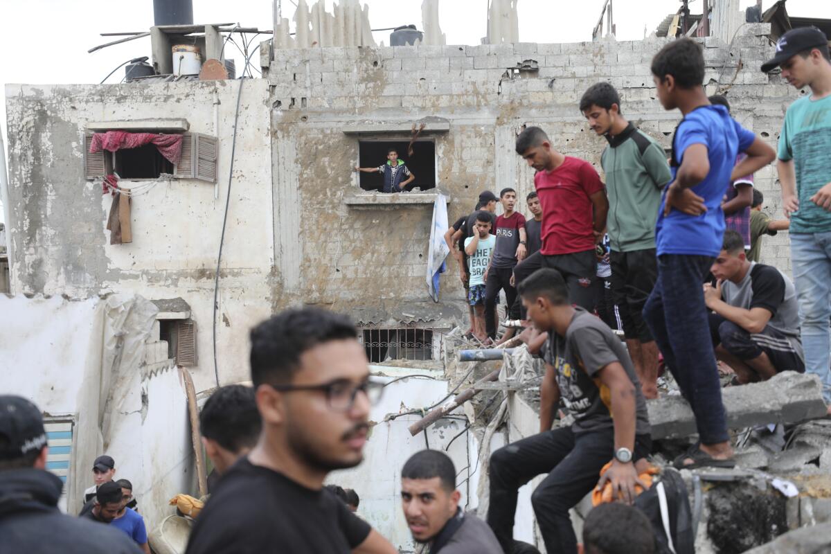 Palestinians inspect the rubble of a destroyed building after an Israeli airstrike in Deir al Balah, Gaza Strip.