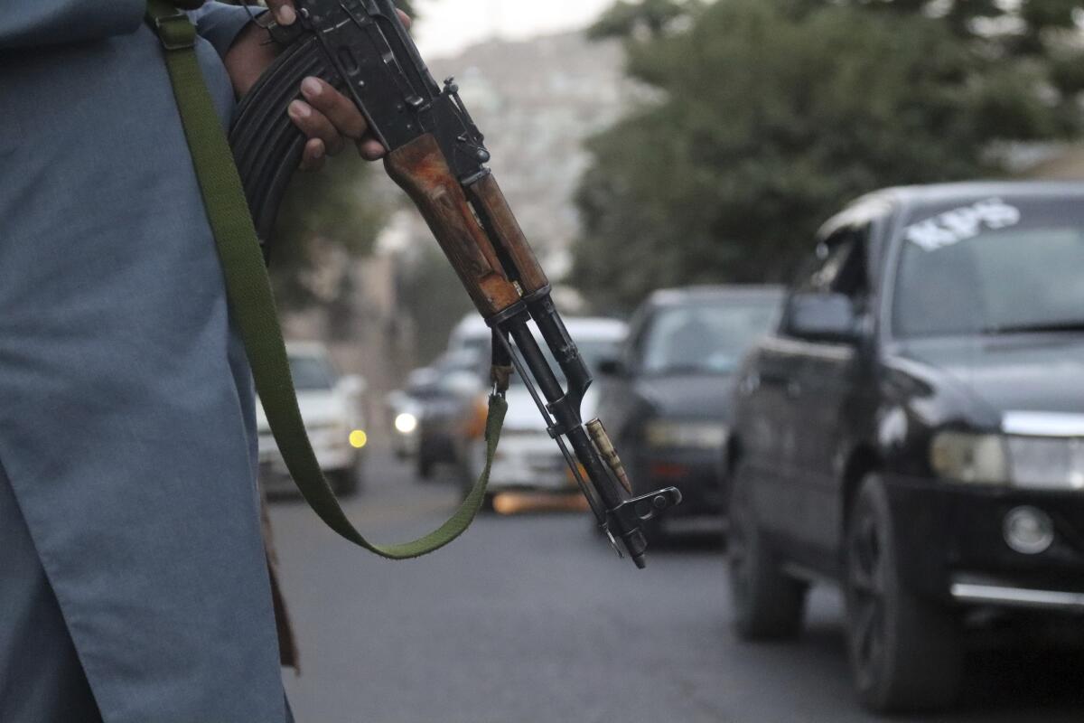 A Taliban fighter patrols a street in Kabul holding a weapon