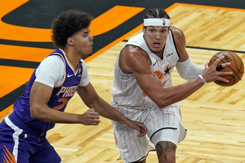 Orlando Magic forward Aaron Gordon, right, looks to pass as he is defended by Phoenix Suns forward Cameron Johnson