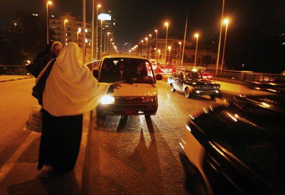 A woman flags down a minibus driver in Cairo.