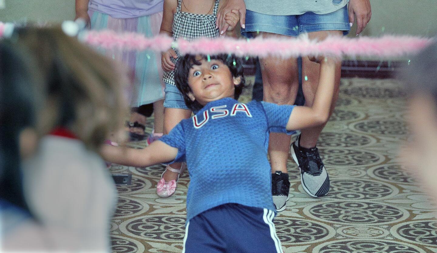 Siddharta Reynolds, 5, of Burbank, bends back in an attempt to get under a fuzzy streamer while doing the Limbo at a Family Sock Hop at the Buena Vista Branch Library in Burbank on Wednesday, September 26, 2018. Many of the children and their parents dressed people did in the 1950s.