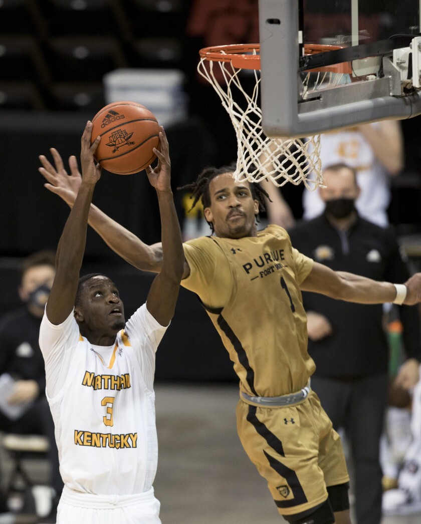 Northern Kentucky guard Marques Warrick (3) is fouled by Purdue-Fort Wayne guard Jarred Godfrey (1) while attempting to dunk during the second half of an NCAA college basketball game Friday, Jan. 1, 2021, in Highland Heights, Ky. (Albert Cesare/The Cincinnati Enquirer via AP)